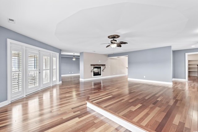 unfurnished living room featuring ceiling fan and hardwood / wood-style floors