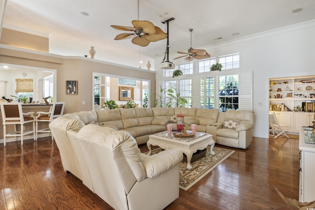 living room featuring dark wood-type flooring, ornamental molding, and ceiling fan