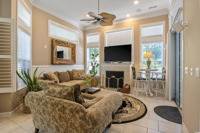 living room with crown molding, a fireplace, plenty of natural light, and ceiling fan