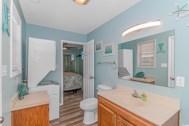 6001-5240 S Kings Hwy, Myrtle Beach, SC 29575 - ensuite bathroom featuring wood finished floors, stacked washer / drying machine, connected bathroom, toilet, and vanity