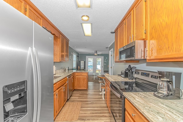 6001-5240 S Kings Hwy, Myrtle Beach, SC 29575 - kitchen featuring stainless steel appliances, light wood-style floors, a textured ceiling, and brown cabinets