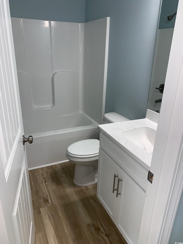 full bathroom with wood-type flooring, tub / shower combination, vanity, and toilet