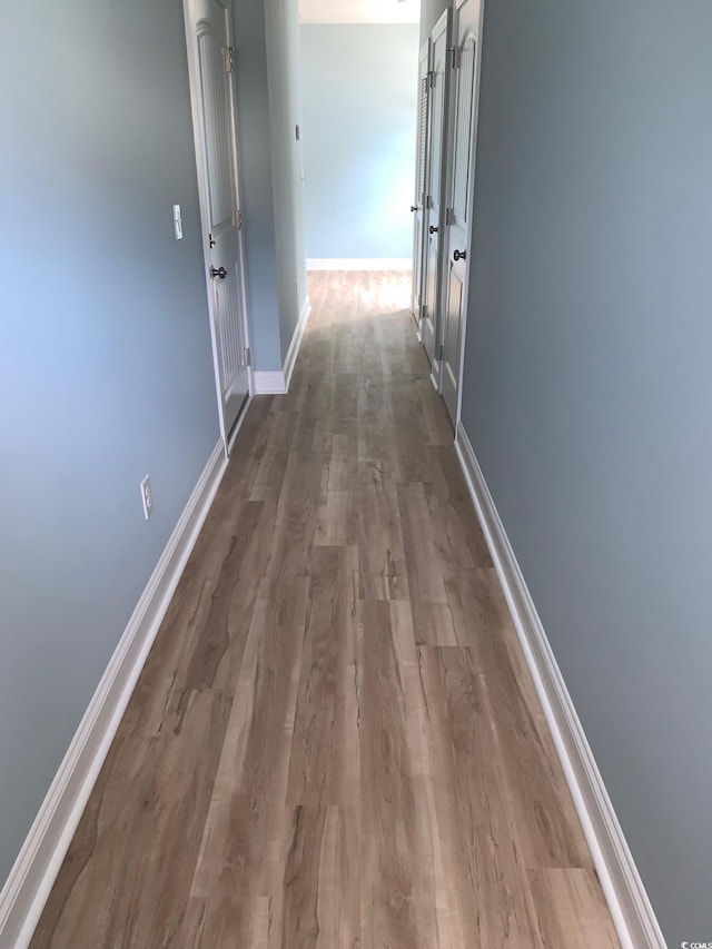 hall with hardwood / wood-style floors