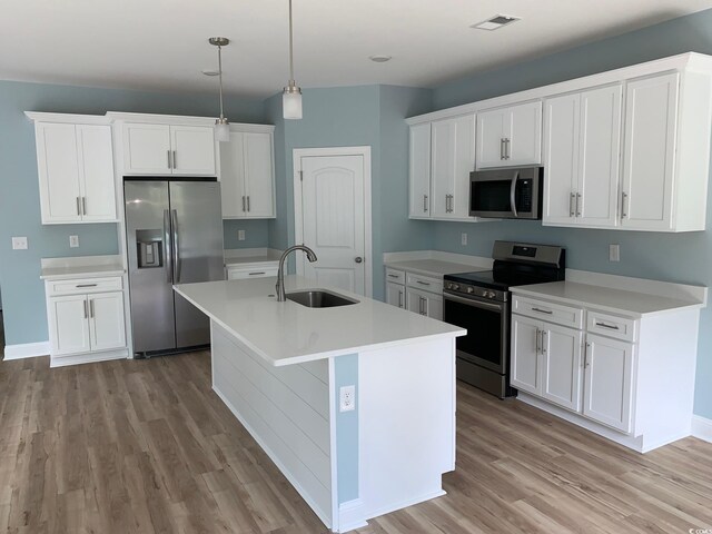 kitchen with stainless steel appliances, light hardwood / wood-style flooring, white cabinets, and sink