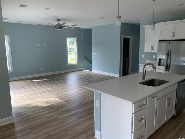 kitchen with white cabinets, sink, wood-type flooring, a kitchen island with sink, and appliances with stainless steel finishes