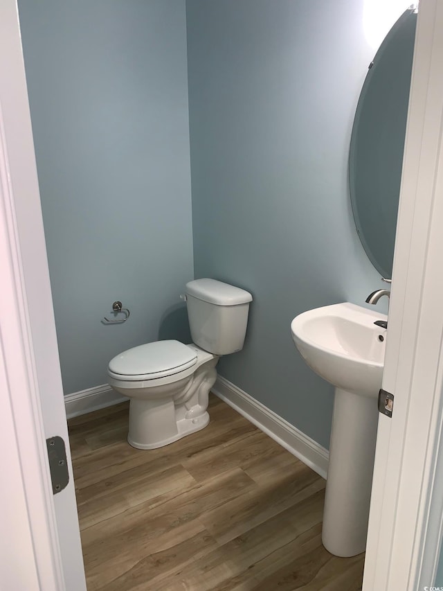 bathroom featuring wood-type flooring, toilet, and sink