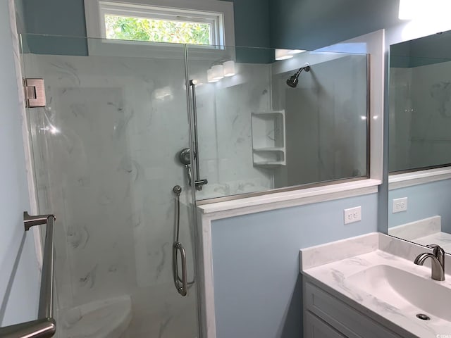 bathroom featuring vanity and a shower with shower door