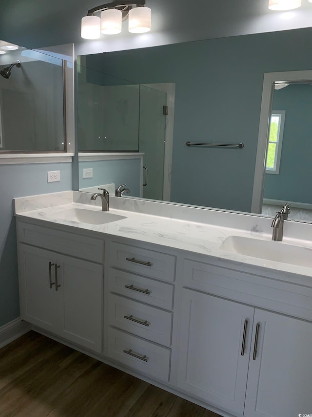 bathroom with walk in shower, vanity, and wood-type flooring