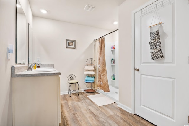 bathroom with vanity, a shower with shower curtain, and wood-type flooring