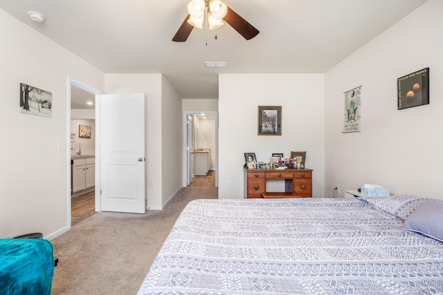 carpeted bedroom with connected bathroom and ceiling fan