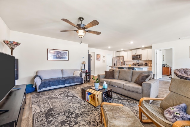 living room featuring ceiling fan and light wood-type flooring