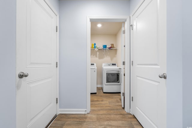 washroom with light hardwood / wood-style floors and washing machine and dryer