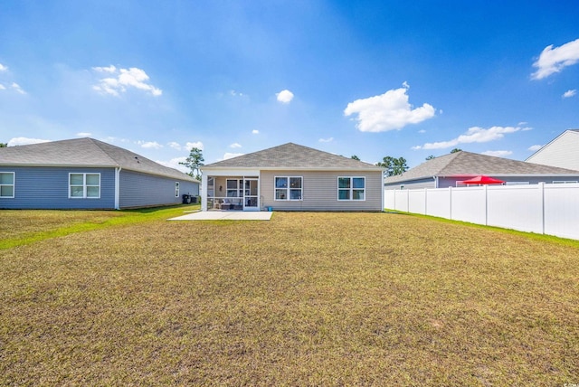 rear view of property with a yard and a patio