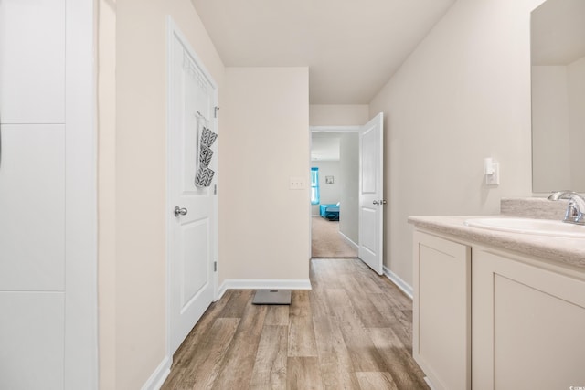 hall with sink and light wood-type flooring