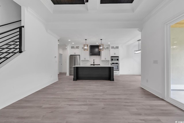 kitchen with white cabinetry, a kitchen island with sink, high quality fridge, pendant lighting, and sink