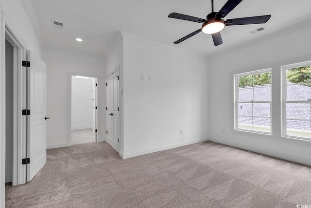 empty room with light carpet, ceiling fan, and crown molding