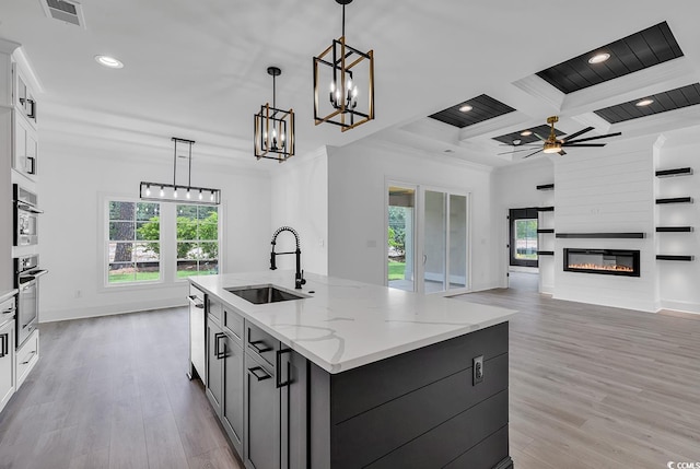 kitchen featuring white cabinetry, coffered ceiling, decorative light fixtures, beam ceiling, and sink