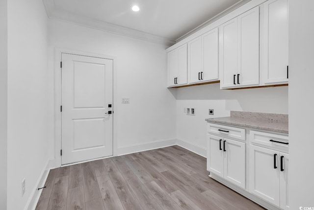 washroom featuring hookup for an electric dryer, light wood-type flooring, washer hookup, cabinets, and crown molding