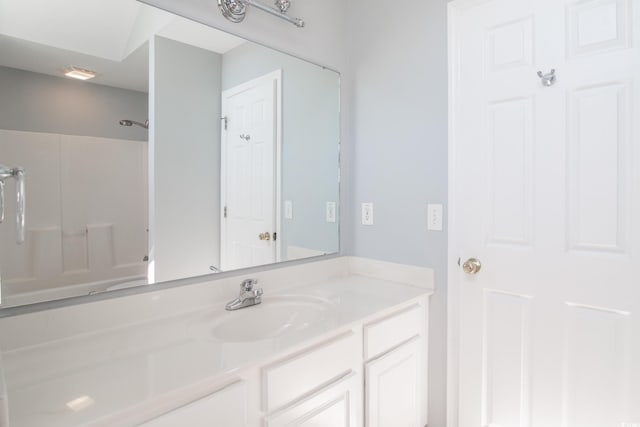 bathroom with vanity and a shower