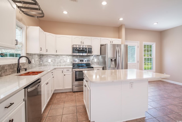 kitchen with sink, a center island, stainless steel appliances, and a healthy amount of sunlight