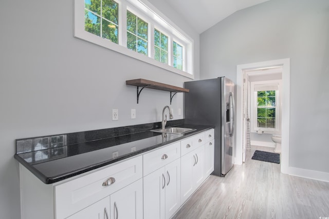 kitchen featuring sink, white cabinets, stainless steel refrigerator with ice dispenser, and a healthy amount of sunlight