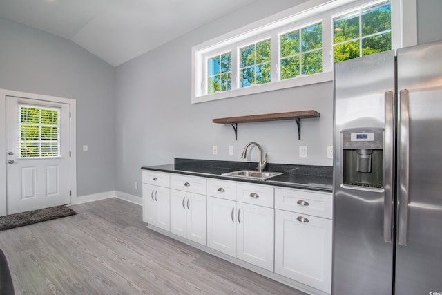 kitchen with lofted ceiling, light hardwood / wood-style flooring, stainless steel refrigerator with ice dispenser, sink, and white cabinetry