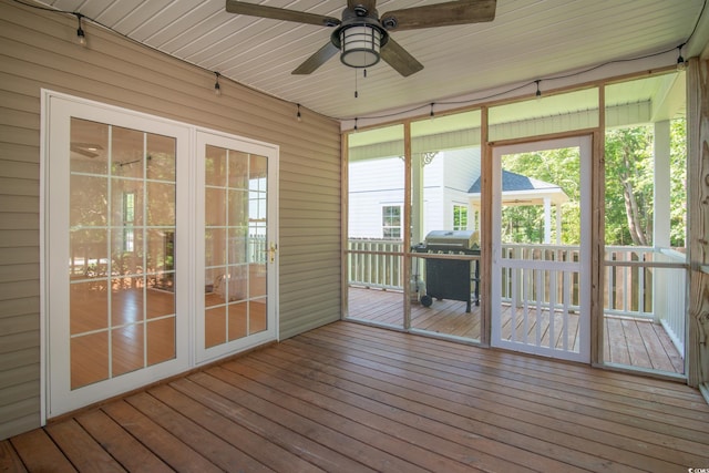 unfurnished sunroom with ceiling fan