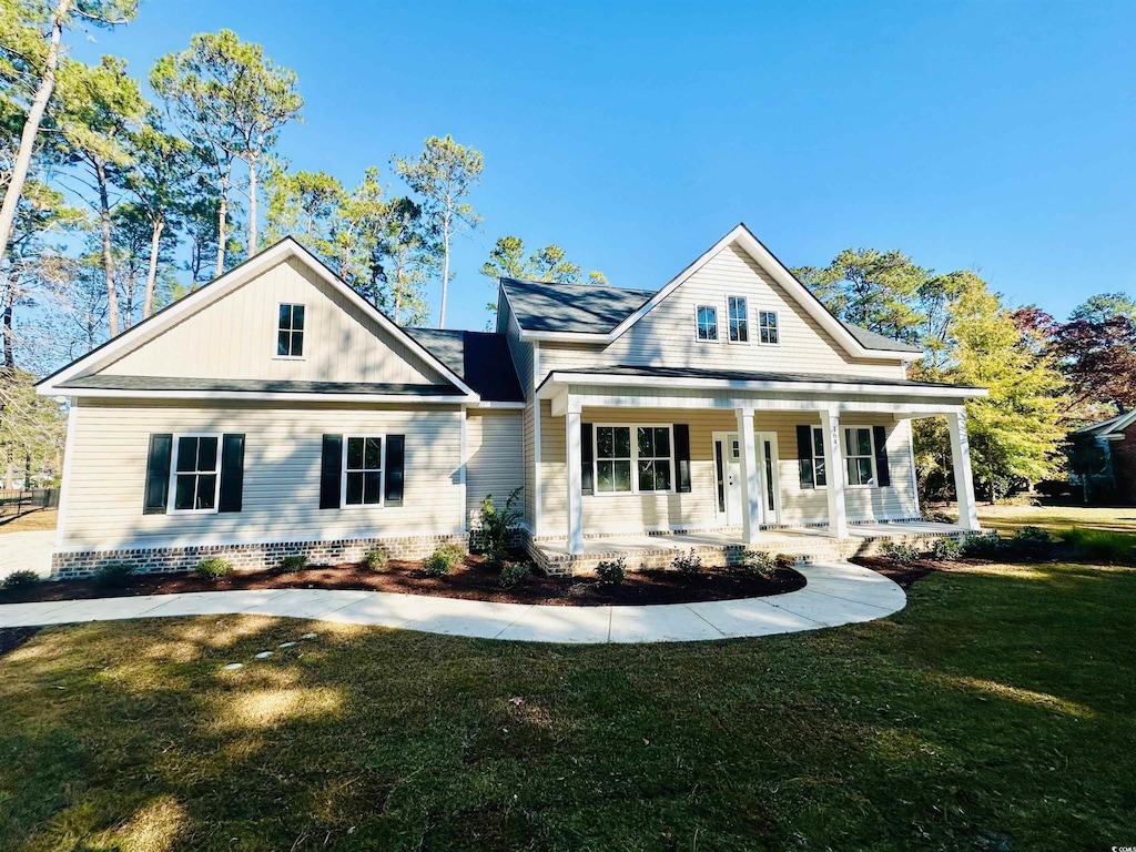 view of front of home featuring covered porch and a front lawn