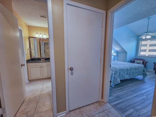 hall with a textured ceiling and light hardwood / wood-style floors