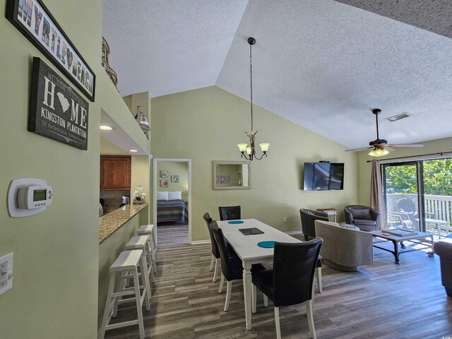 living room with ceiling fan, a textured ceiling, light hardwood / wood-style flooring, and lofted ceiling