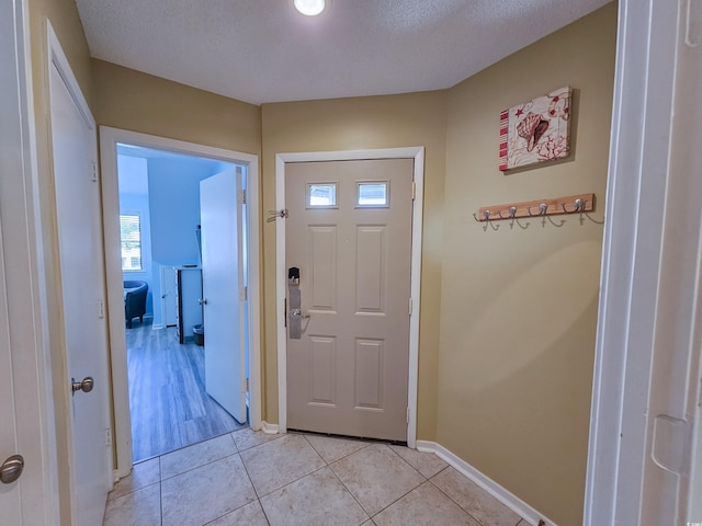 entryway featuring a textured ceiling and light tile patterned floors