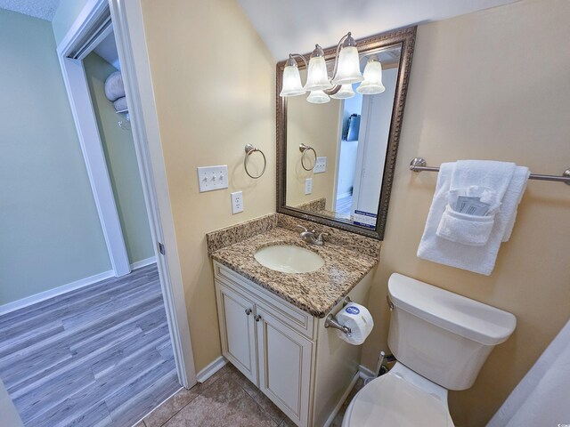 bathroom with ceiling fan, a textured ceiling, hardwood / wood-style flooring, and vanity