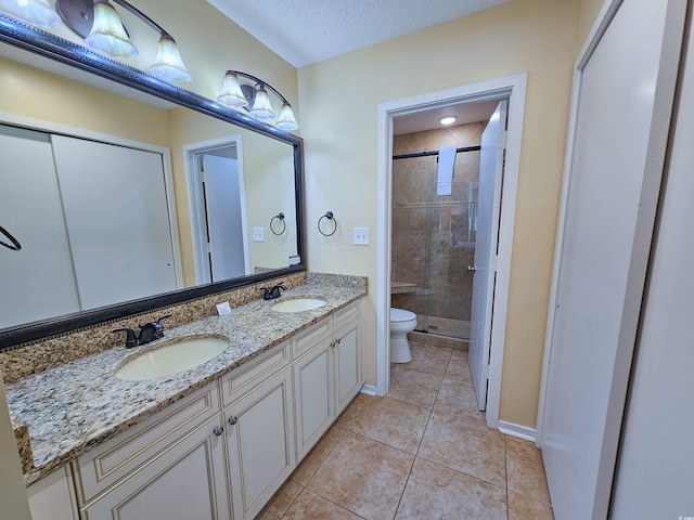 bathroom featuring vanity, toilet, a textured ceiling, tile patterned flooring, and a shower with door