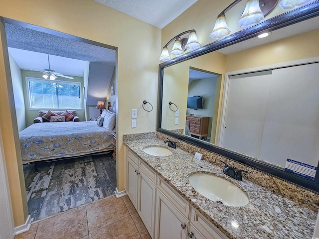 bathroom with a textured ceiling, tile patterned flooring, vanity, and ceiling fan