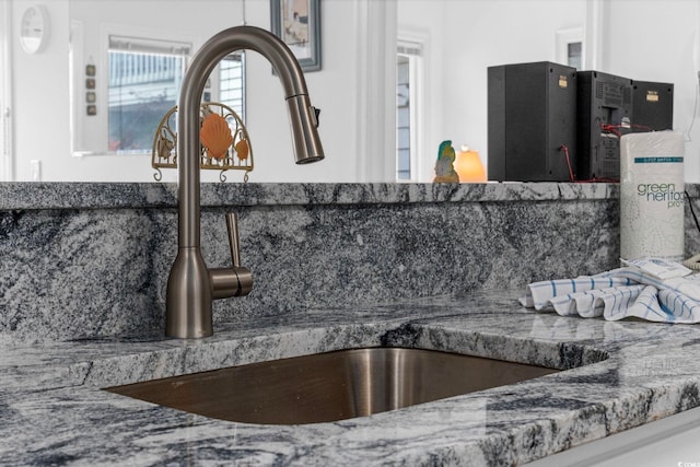 interior details featuring a sink and backsplash