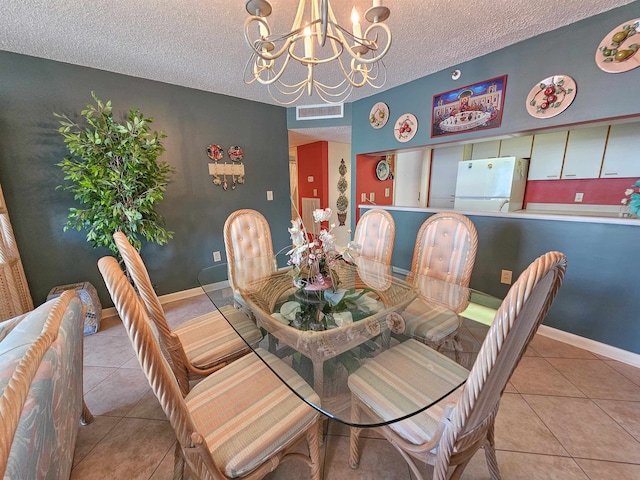 dining area with a notable chandelier, a textured ceiling, and light tile flooring