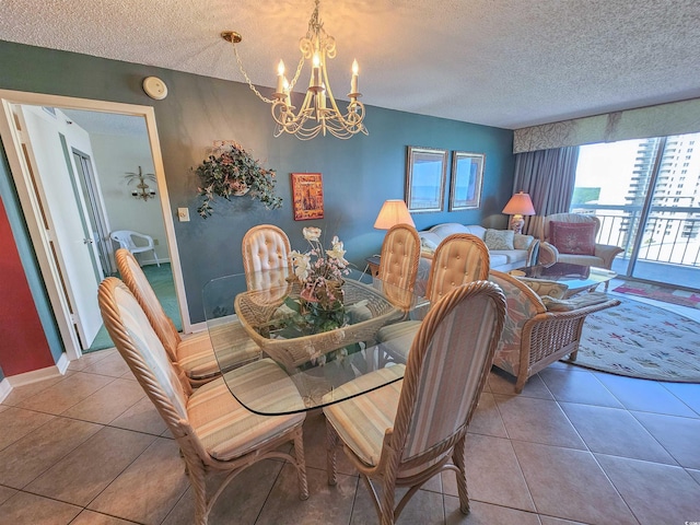 dining room featuring a chandelier, a textured ceiling, and tile floors