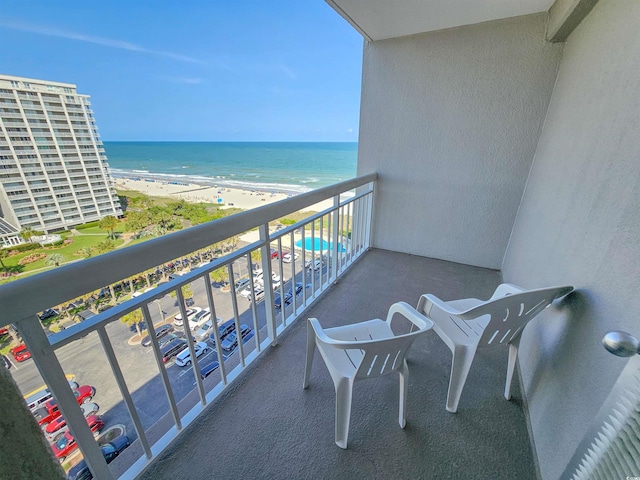 balcony featuring a beach view and a water view