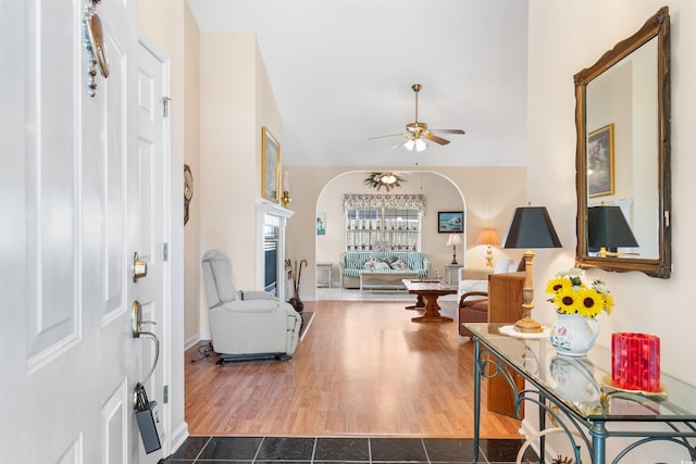 foyer entrance with ceiling fan and dark tile patterned flooring