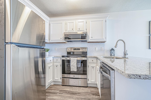 kitchen with sink, decorative backsplash, a textured ceiling, white cabinetry, and stainless steel appliances