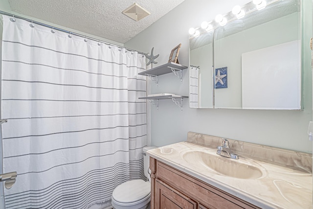 bathroom with vanity, a textured ceiling, and toilet