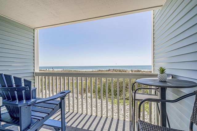 balcony featuring a beach view and a water view