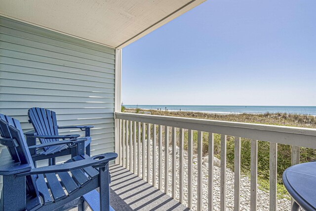 balcony featuring a beach view and a water view