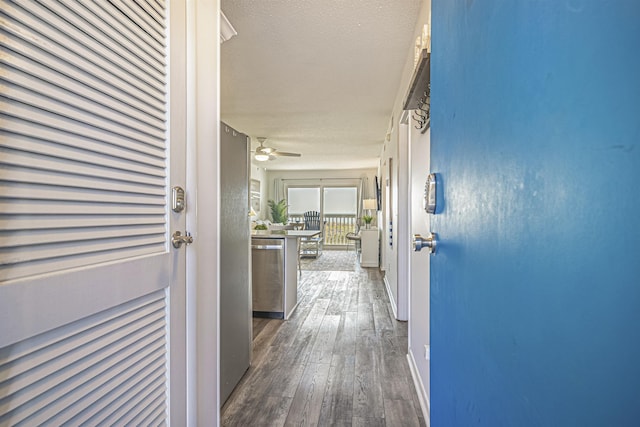 hall featuring dark wood-type flooring and a textured ceiling