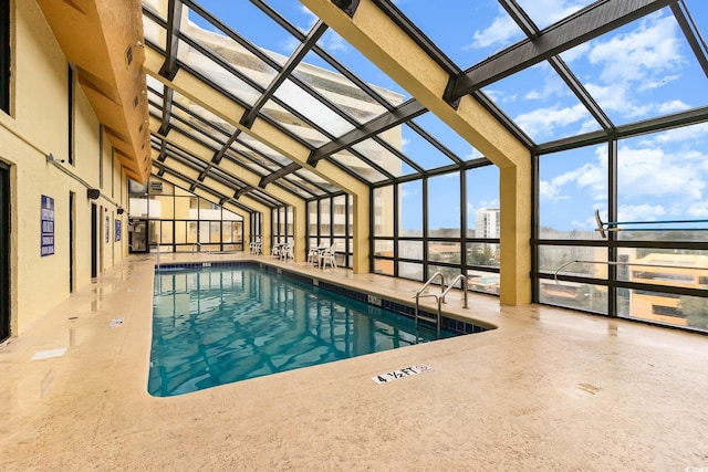 view of swimming pool with glass enclosure and a patio