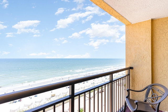 balcony featuring a water view and a view of the beach