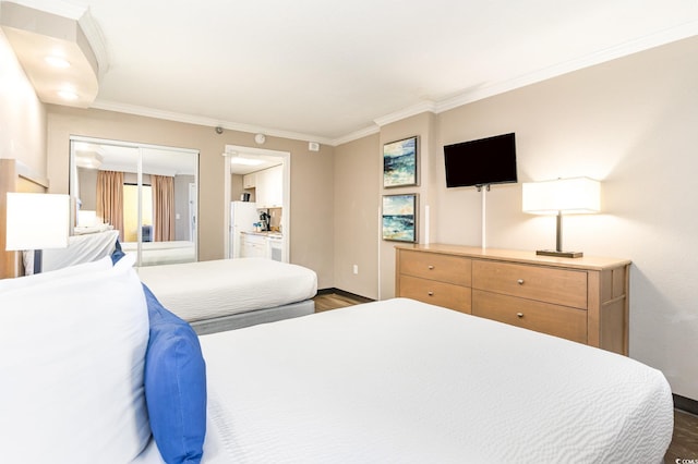 bedroom featuring white refrigerator, dark hardwood / wood-style floors, a closet, and ornamental molding