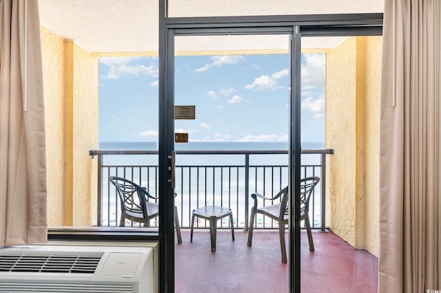 balcony featuring heating unit and a water view