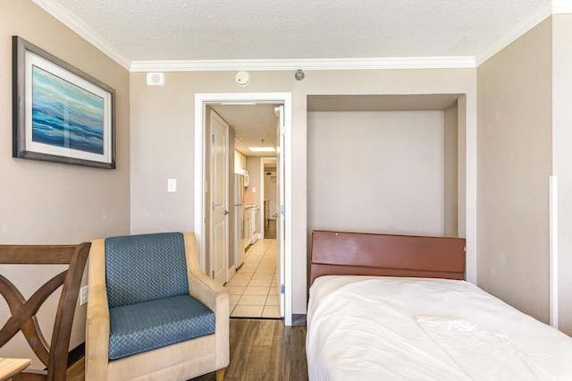 bedroom featuring wood-type flooring, a textured ceiling, and ornamental molding