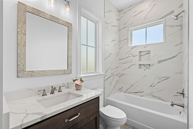 full bathroom featuring toilet, vanity, and tiled shower / bath